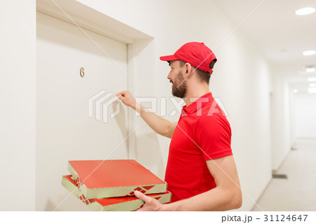 delivery man with pizza boxes knocking on door 31124647