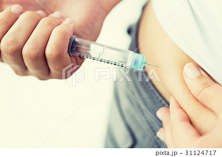 close up of hands making injection by insulin pen close up of hands making injection by insulin pen 31124717