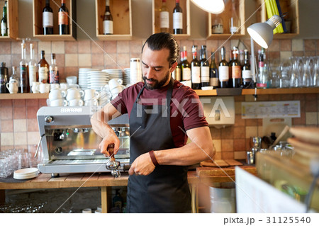 barista with holder and tamper making at coffee barista with holder and tamper making at coffee 31125540