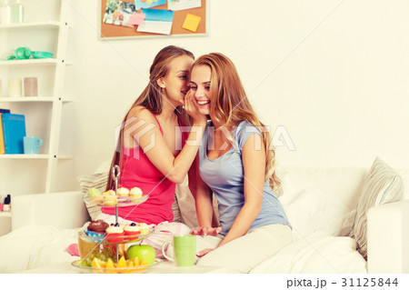 young women drinking tea and gossiping at home 31125844