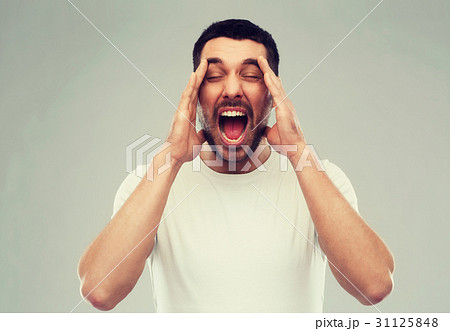 crazy shouting man in t-shirt over gray background 31125848