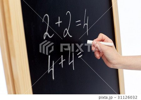 hand with chalk writing numbers on blackboard hand with chalk writing numbers on blackboard 31126032