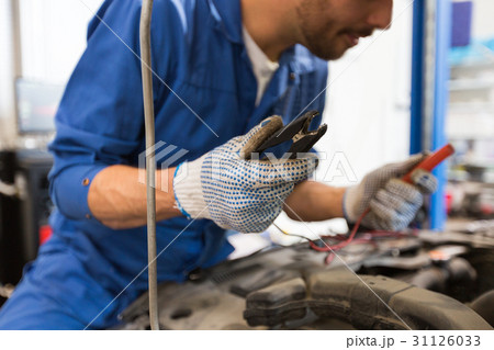 auto mechanic man with cleats charging battery auto mechanic man with cleats charging battery 31126033