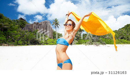 woman in bikini and sunglasses with pareo on beach woman in bikini and sunglasses with pareo on beach 31126163