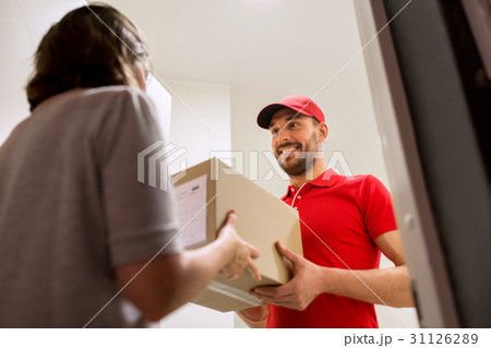 happy delivery man giving parcel box to customer 31126289