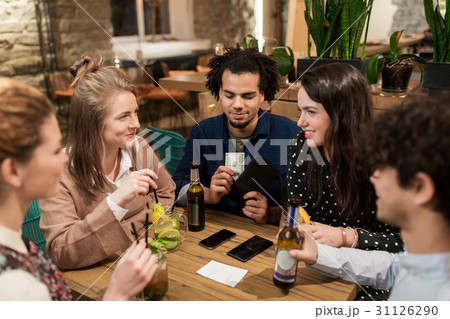 friends with drinks, money and bill at bar 31126290