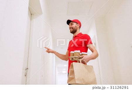 delivery man with coffee and food ringing doorbell 31126291