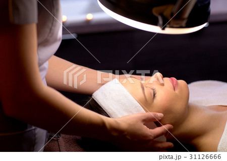 beautician doing face massage to woman at spa beautician doing face massage to woman at spa 31126666