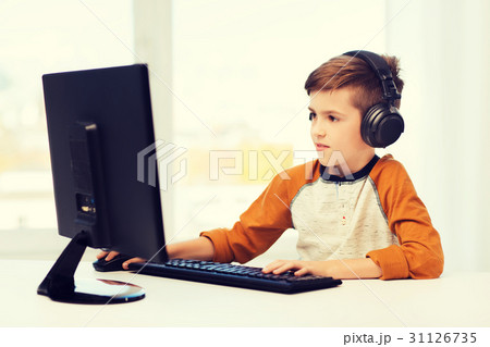 happy boy with computer and headphones at home 31126735