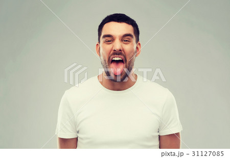 man showing his tongue over gray background 31127085
