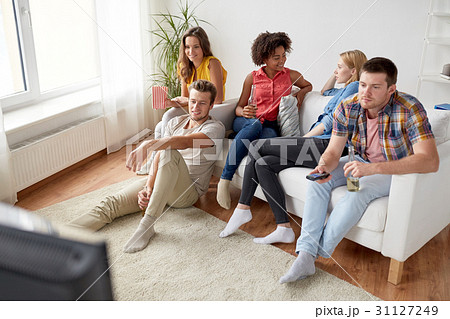 friends with popcorn and beer watching tv at home friends with popcorn and beer watching tv at home 31127249