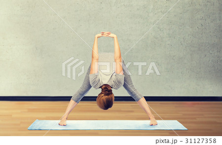 woman making yoga in wide-legged forward bend pose 31127358