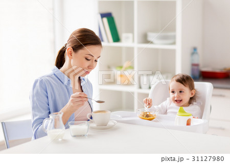 happy mother and baby having breakfast at home happy mother and baby having breakfast at home 31127980