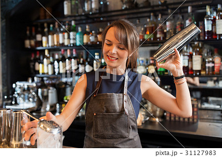barmaid with shaker preparing cocktail at bar 31127983