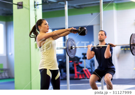 man and woman with weights exercising in gym man and woman with weights exercising in gym 31127999