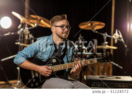 man playing guitar at studio rehearsal 31128572