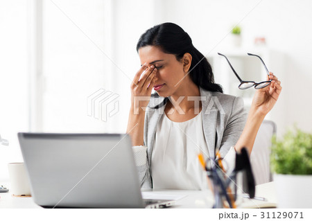 businesswoman rubbing tired eyes at office businesswoman rubbing tired eyes at office 31129071