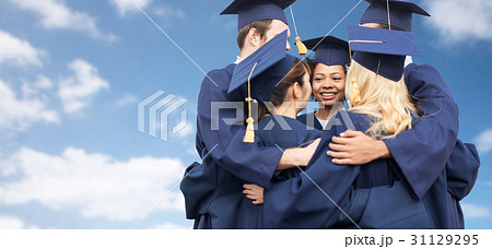 happy students or bachelors hugging over blue sky 31129295