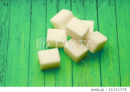 Sugar cubes on green wooden background Sugar cubes on green wooden background 31131779