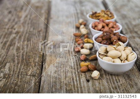 Nuts in a plate on a  wooden table. 31132543