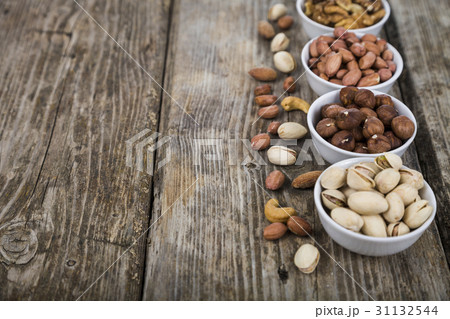 Nuts in a plate on a  wooden table. 31132544
