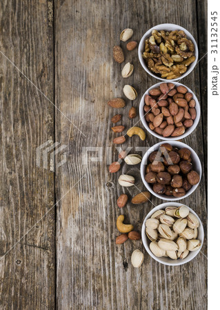 Nuts in a plate on a  wooden table. 31132545