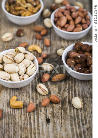 Nuts in a plate on a  wooden table. 31132546