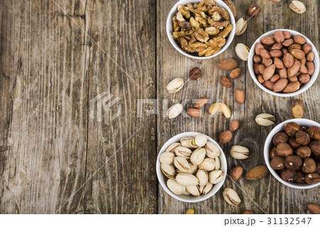Nuts in a plate on a  wooden table. 31132547