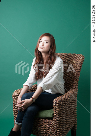 椅子で足を組む女性の写真素材