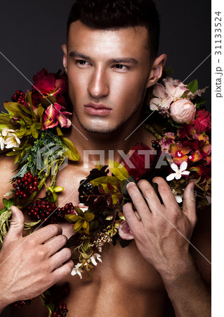 A handsome man with a naked torso, bronze tan and 31133524