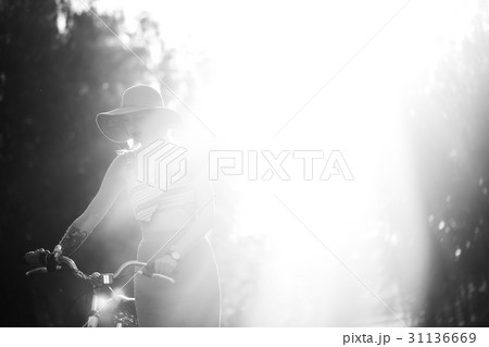 Silhouette of girl driving bicycle outdoor. Sunny Silhouette of girl driving bicycle outdoor. Sunny 31136669