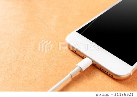 Smartphone charging with power bank on wood board 31136921