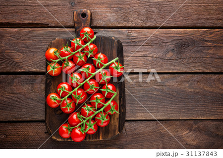 Fresh cherry tomatoes on twigs on wooden table Fresh cherry tomatoes on twigs on wooden table 31137843