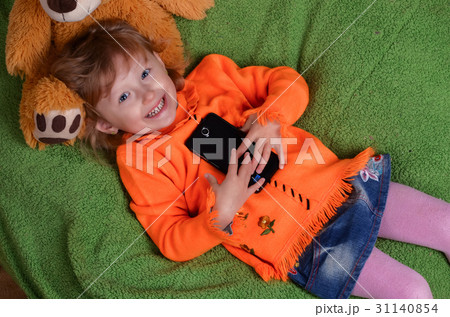 little girl lying on a big green pillow 31140854