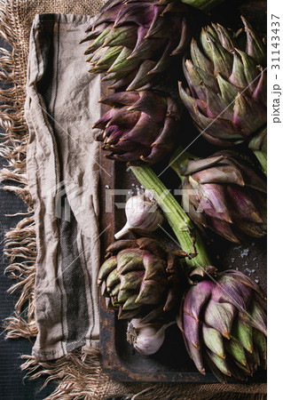 Uncooked purple artichokes Uncooked purple artichokes 31143437