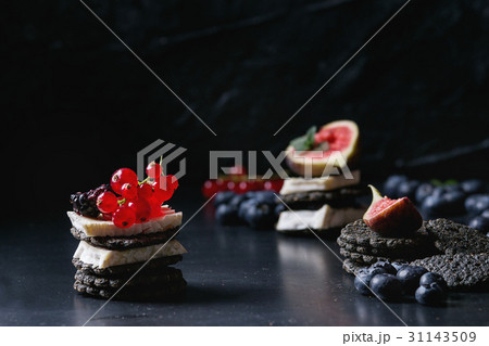 Black crackers with cheese and berries Black crackers with cheese and berries 31143509
