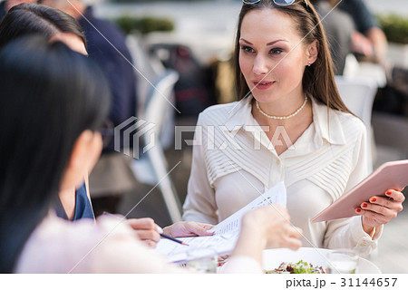 Happy woman telling with colleagues at table 31144657