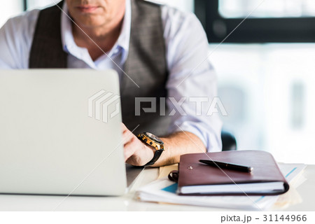 Confident senior gentleman working in office 31144966