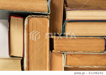 Stack of hardback books on table. Top view. 31146242