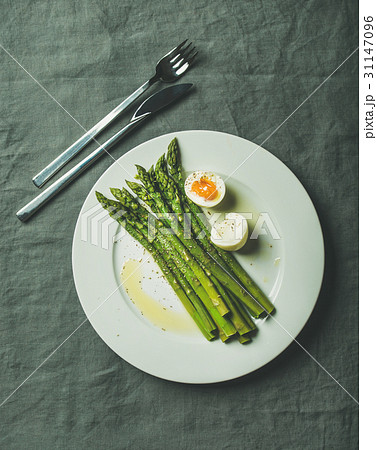 Cooked asparagus with soft-boiled egg and herbs on 31147096