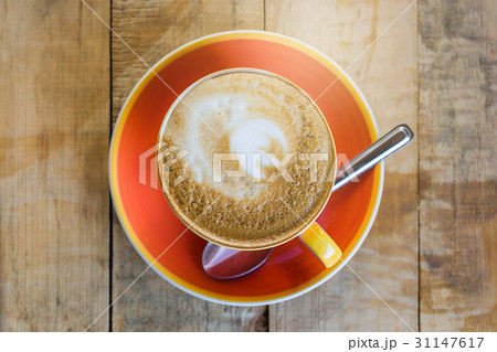 orange cup of coffee latte art with leaf pattern 31147617