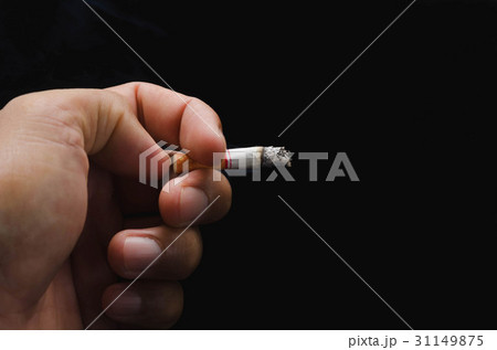hand holding cigarette and smoke on black 31149875