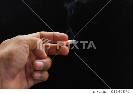 hand holding cigarette and smoke on black hand holding cigarette and smoke on black 31149876