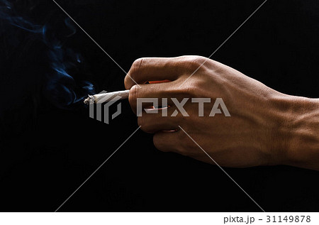 hand holding cigarette and smoke on black 31149878