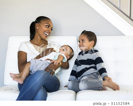 Mother with two sons (2-5 months, 2-3) on sofa 31152584