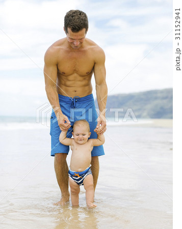 Son (12-17 months) learning to walk with father on beach 31152941