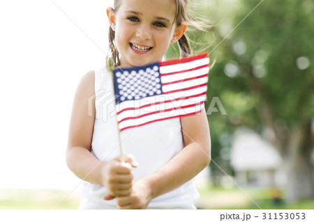 Girl (4-5) holding american flag 31153053