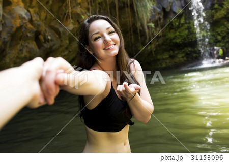 Caribbean Islands, Saint Lucia, Woman by water holding person's hand and looking at camera Caribbean Islands, Saint Lucia, Woman by water holding person's hand and looking at camera 31153096