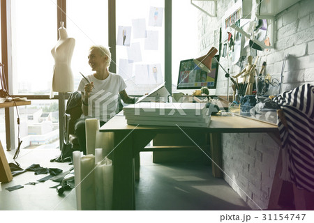 Fashion designer tattooed girl on her workspace Fashion designer tattooed girl on her workspace 31154747