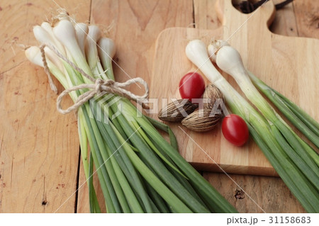 Fresh green onions on wood background. 31158683
